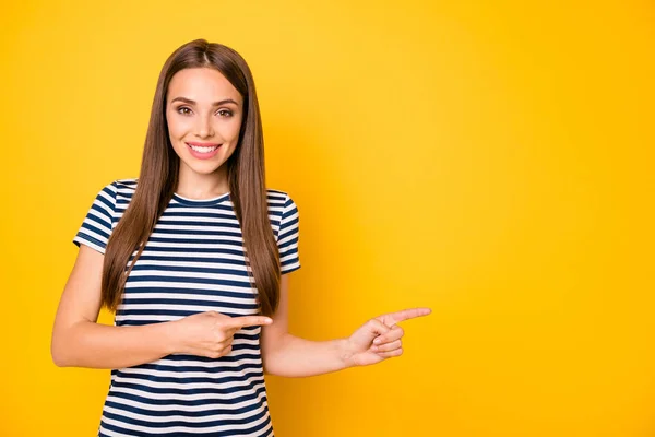 Foto van mooie dame die wijst op de lege ruimte slijtage gestreepte t-shirt geïsoleerd gele achtergrond — Stockfoto