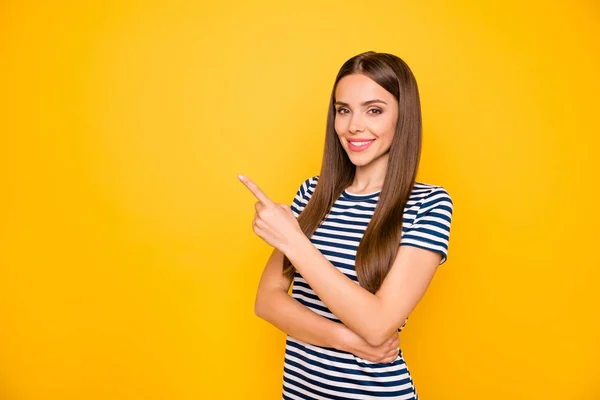 Foto van vriendelijke dame die wijst vinger lege ruimte op lage prijzen slijtage gestreepte t-shirt geïsoleerd gele achtergrond — Stockfoto