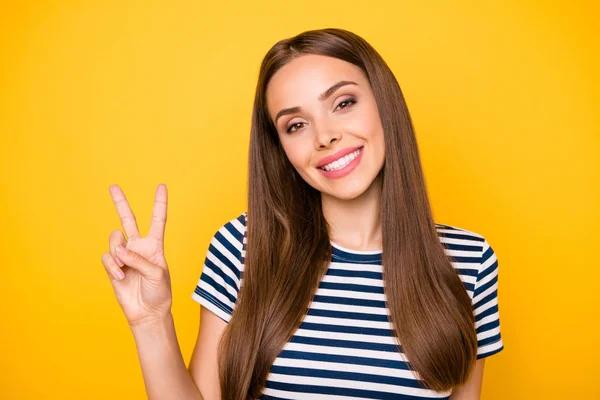 Fechar foto de senhora doce fazendo v-sinais olhando para a câmera sorrindo vestindo listrado t-shirt isolado sobre fundo amarelo — Fotografia de Stock