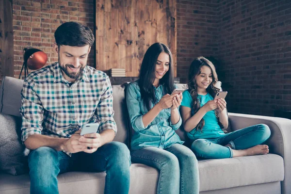 Close-up foto van vrolijke moeder Papa klein kind gebruik apparaat look Wear geruit geruite overhemd denim jeans zitten divan in huis binnenshuis — Stockfoto