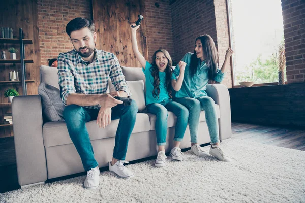 Portrait of delighted small girl champion with brunette hair scream yeah sitting divan with father wearing denim jeans plaid shirt lose race in house indoors — Stock Photo, Image