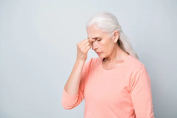Фото грустного расстройства, страдающего от острой боли в голове у бабушки в персиковом цвете пуловера изолированный серый фон — стоковое фото