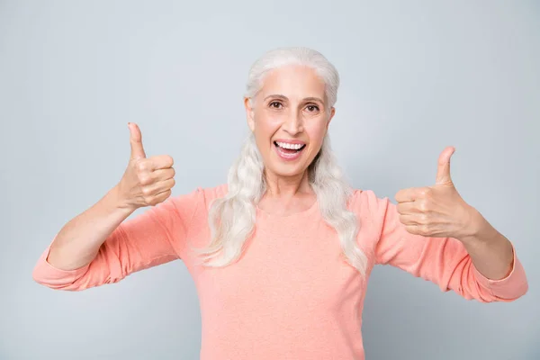 桃色プルオーバーを着て二本指を上げる良い気分のおばあちゃんを持つ肯定的な楽観的なクローズアップ写真 — ストック写真