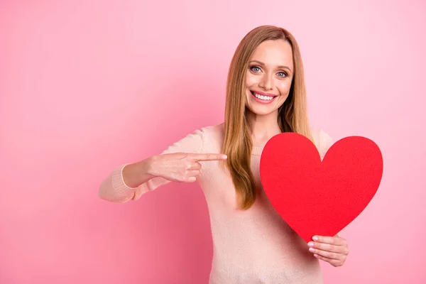 Foto der schönen Dame halten Hand großes Papier Herz Figur Einladung Abschlussball zeigen Finger tragen Pastell Pullover isoliert rosa Hintergrund — Stockfoto