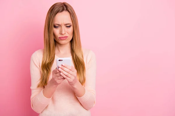 Retrato de desapontado senhora segurar mão gadget olhar notícias feed não entender posts isolados sobre fundo rosa — Fotografia de Stock