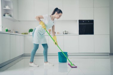 Photo of amazing astonishing girlfriend supporting her mother about cleaning kitchen up while she is lying on bed clipart