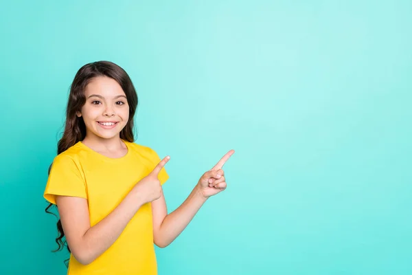 Foto gadis manis yang manis tersenyum menunjuk kekosongan di sebelah kiri di atas sementara terisolasi dengan latar belakang pirus — Stok Foto