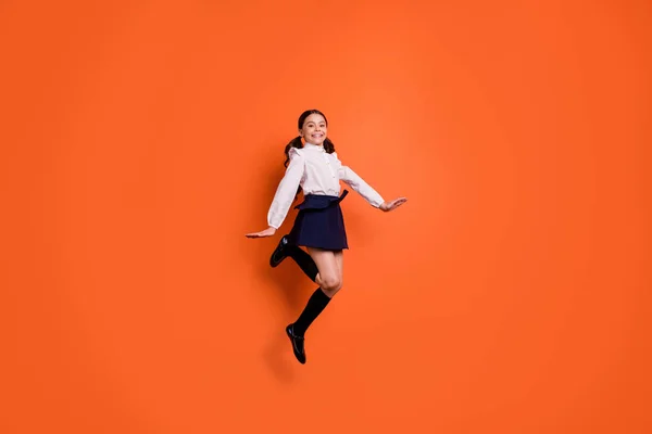 Celá délka tělo velikost zobrazit fotka veselý rozkošný děvče dítě dítě pocit spokojenosti s volným časem škola nosit sukně šaty bílá blůza boty tričko módní moderní styl izolované oranžové pozadí — Stock fotografie