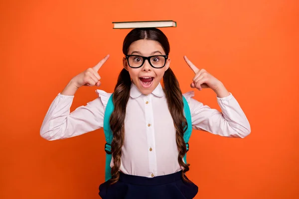 Mochila retrato mochila mochila escuela primaria niño mantenga impreso libro cabeza grito wow omg gafas gafas gafas blusa romper falda moda elegante coletas cola de caballo aislado naranja fondo — Foto de Stock