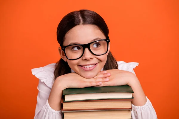 Close-up foto van creatief schattig kind hebben gedachten kennis materialen geïnspireerd slijtage witte blouse shirt handen geïsoleerd oranje levendige achtergrond — Stockfoto
