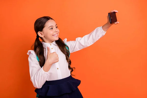 Perfil de vista lateral de la foto de la gente de la escuela primaria agradable hacer fotos videollamada en vivo aprobar el estudio de desgaste blusa blanca falda vestido de moda colas elegantes aislado fondo naranja —  Fotos de Stock