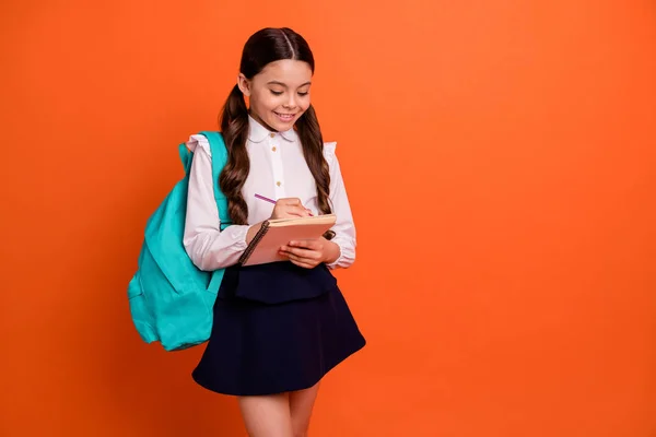 Portret van charmante leuke Kid kind houden hand organiseren notitieboek gevoel positieve gedichten Auteur geïsoleerde slijtage moderne rok shirt blouse oranje levendige achtergrond — Stockfoto