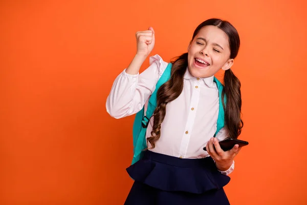 Retrato encantador loco extático pequeño lindo niño cerrar los ojos levantar los puños triunfo ella su campeón grito grito sí sí sí moda elegante falda blusa vestido coletas coletas cola de caballo aislado fondo naranja —  Fotos de Stock