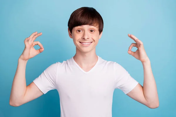 Foto van leuke vrolijke grappige interessante jongen die je laat zien hoe zijn keuze perfect is, terwijl geïsoleerd met blauwe achtergrond — Stockfoto