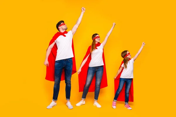 Rodinné příslušníky hrající kreslené neuvěřitelné postavy zachraování světa nosit superhrdina létání pláště izolované žluté pozadí — Stock fotografie