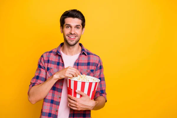 Foto de disfrutar del hombre viendo su película favorita y comiendo maíz pop mientras está aislado con fondo amarillo — Foto de Stock