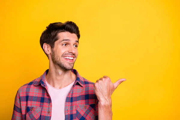 Foto van knappe man wijzend op leegte met zijn duim om uw beste keuze te tonen om uw leven te veranderen, terwijl geïsoleerd met een gele achtergrond — Stockfoto