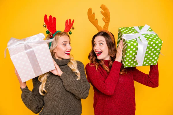Photo of two amazed ladies received big giftboxes for xmas wear sweaters and head horns isolated yellow background — Stock Photo, Image
