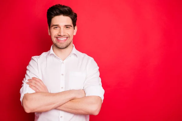 Portret van vrolijke kerel met zijn handen gevouwen glimlachend dragen wit overhemd geïsoleerd over rode achtergrond — Stockfoto