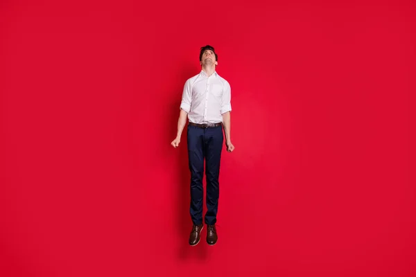 Foto de cuerpo entero de hombre de negocios blanco usando pantalones saltando escaleras de carrera mientras está aislado con fondo rojo —  Fotos de Stock