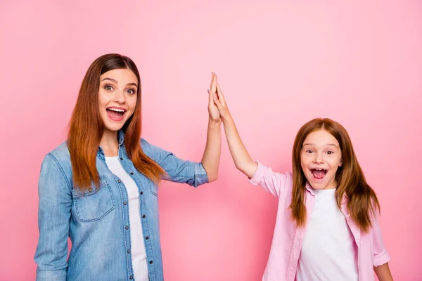 Porträtt av upphetsad damer med lång frisyr klappar händer skrek Ja bär denim jeans skjorta isolerad över rosa bakgrund — Stockfoto