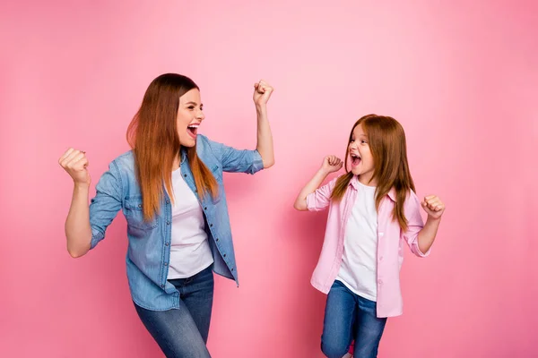 Foto del lado del perfil de personas alegres levantando los puños gritando sí usando jeans camisa de mezclilla aislada sobre fondo rosa — Foto de Stock