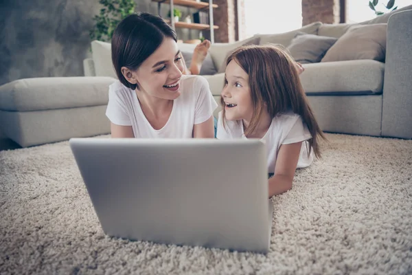 Sevimli öğrenci küçük çocuk kapalı beyaz t-shirt giyen gülen netbook izlemek yerde yatan fotoğrafı kapatın — Stok fotoğraf