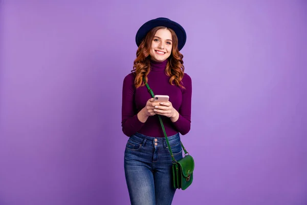 Retrato da moda encantador jovem segurar mão moderna tecnologia desgaste jeans jeans isolado sobre fundo violeta — Fotografia de Stock