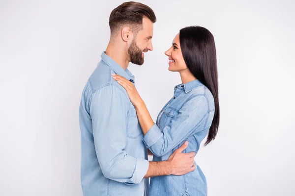 Foto del lado del perfil de personas casadas alegres abrazándose sonriendo usando jeans camisa aislada sobre fondo blanco —  Fotos de Stock