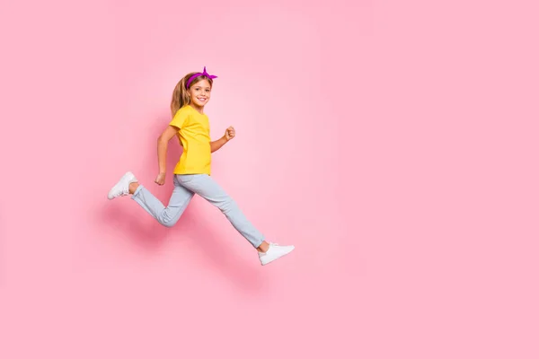 Comprimento total tamanho do corpo vista dela ela agradável atraente agradável alegre alegre pré-adolescente menina vestindo amarelo t-shirt maratona de corrida isolado sobre fundo rosa — Fotografia de Stock