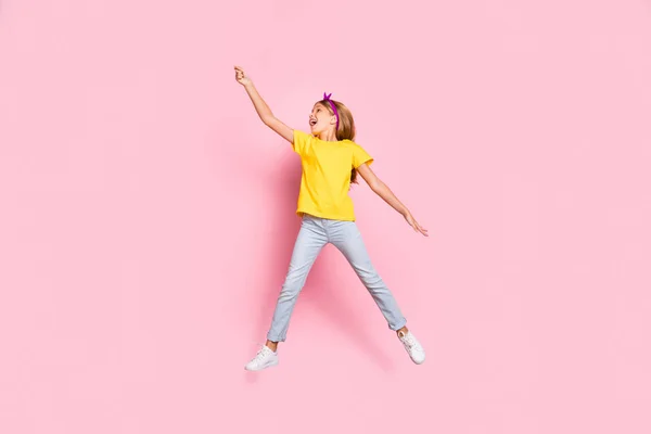 Longitud completa vista del tamaño del cuerpo de ella ella agradable alegre alegre alegre alegre alegre despreocupado pre-adolescente niña con camiseta amarilla divertirse sosteniendo en la mano invisible parasol aislado sobre fondo rosa —  Fotos de Stock