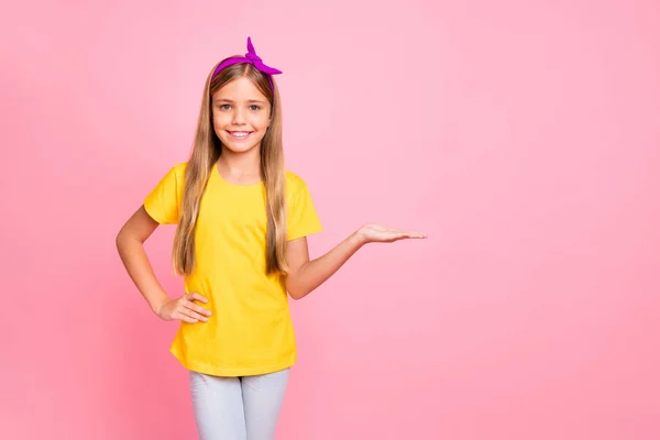 Foto de boa menina alegre amigável agradável segurando algo com a mão enquanto isolado com fundo rosa — Fotografia de Stock