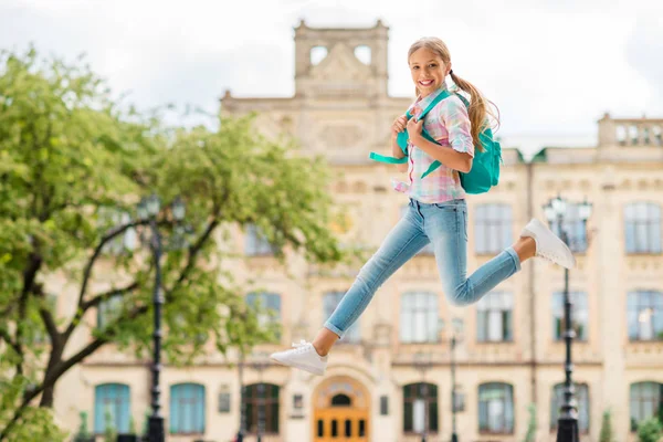 Volledige lengte profiel kant foto van vrolijke meid met staartjes paardenstaarten houden rugzak rugzak dragen geruite geruite t-shirt denim jeans — Stockfoto