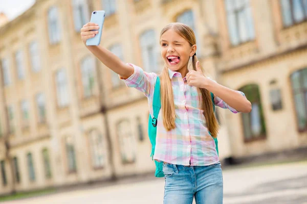 Retrato de criança engraçada humorística com tranças rabo de cavalo grimace fazer foto aprovar cursos realizar mochila mochila desgaste xadrez t-shirt jeans jeans stand out — Fotografia de Stock