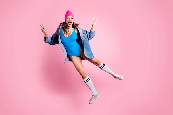 Фотографія веселої жінки, що робить v-знаки в блакитному купальнику ізольовані на рожевому фоні — стокове фото