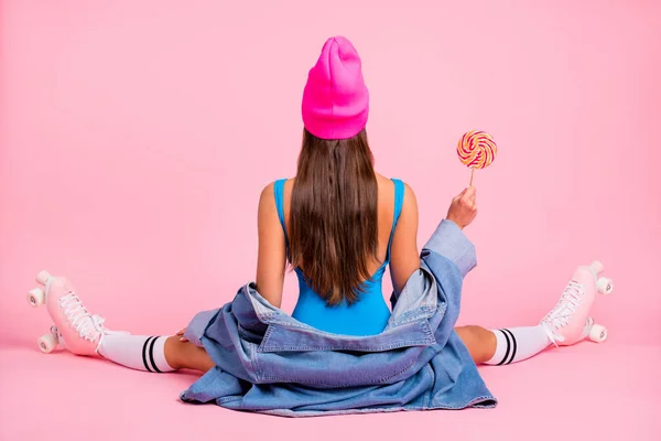 На задній стороні повнорозмірна фотографія чарівної дівчини в шапочці фуксії, що сидить у купальнику, ізольовані на рожевому фоні — стокове фото