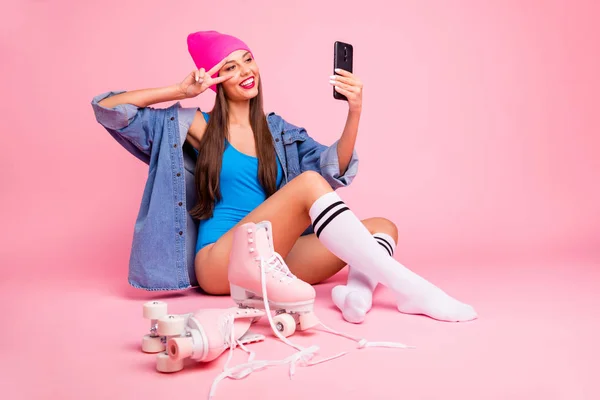 Full body photo of pretty woman wearing cap hat blue bodysuit socks making photo v-signs isolated over pink background — Stock Photo, Image