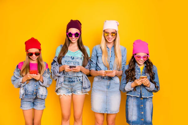 Close-up photo of group of four people influencers using posting following subscribing new sites searching news reading news-feed wearing hat cap sunglass isolated bright background — Stock Photo, Image