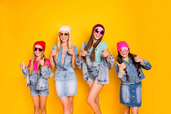 Φωτογραφία του τέσσερις όμορφη αυτοπεποίθηση γοητευτικό αρκετά χαρούμενο ενθουσιασμένος θετική αστεία έφηβος μελαχρινή ξανθιά κυρίες δίνοντας δάχτυλο πάνω σύμβολα φορώντας ζεστή σεζόν άνοιξη ρούχα απομονωμένη κίτρινο φόντο — Φωτογραφία Αρχείου