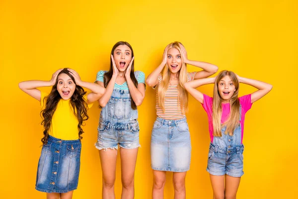 Photo of four cheerful with amazed facial expression open mouth shouting screaming ladies wearing denim overalls colorful t-shirts isolated bright background — Stock Photo, Image