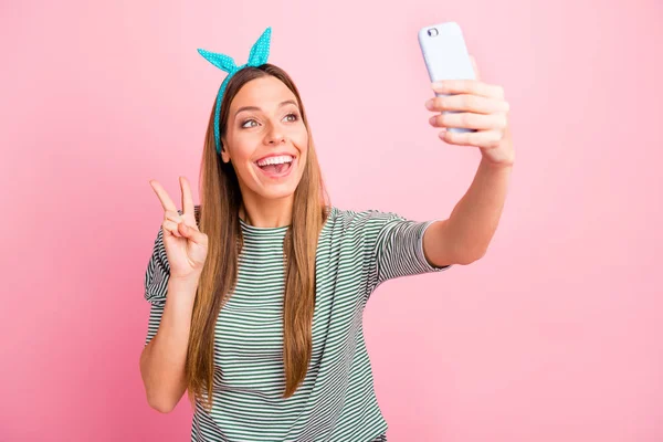 Zabawna dama robienia selfie z symbolem v-znak nosić pasiasty sweter na białym tle różowy — Zdjęcie stockowe