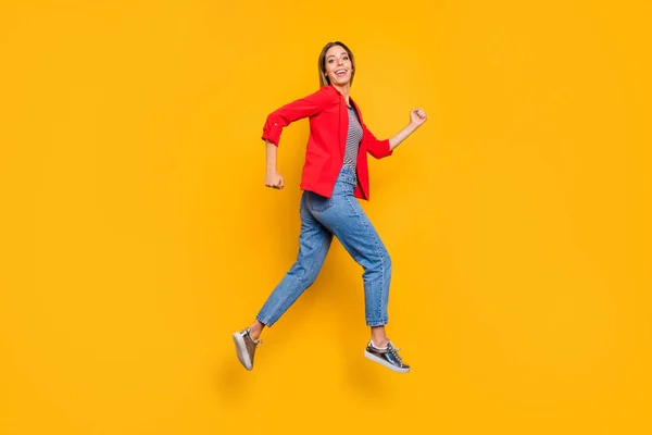 Foto de larga duración de una bonita persona corriendo sonriente vistiendo una camisa de rayas rojas vaqueros aislados sobre fondo amarillo —  Fotos de Stock
