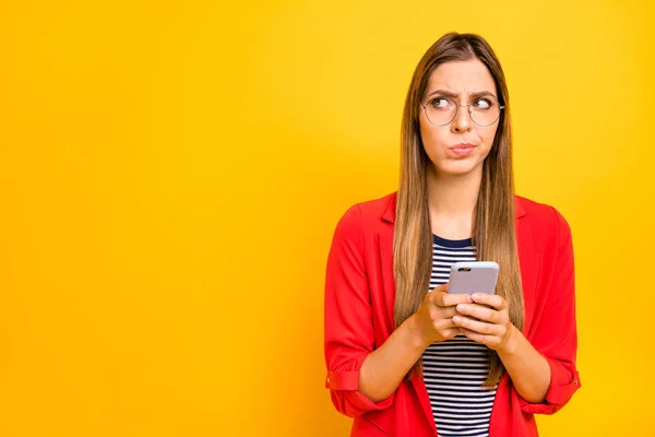 Portret van onzeker persoon houden gadget dragen brillen brillen geïsoleerd over gele achtergrond — Stockfoto