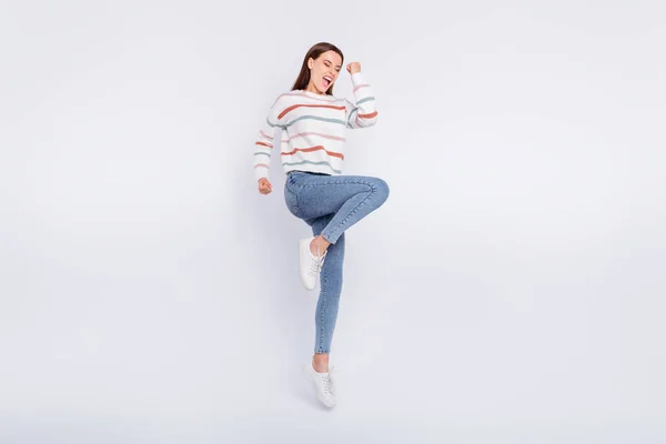 Foto de tamaño completo de la mujer encantada con los ojos cerrados levantando puños gritando sí usando jersey a rayas aislado sobre fondo blanco — Foto de Stock