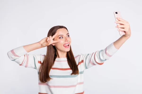 Αστεία κυρία κάνοντας selfie δείχνοντας v-Sign σύμβολο φορούν ριγέ πουλόβερ απομονωμένο λευκό φόντο — Φωτογραφία Αρχείου