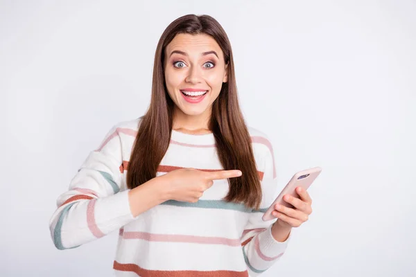 Mooie dame met telefoon in handen wijzen vinger op apparaat scherm slijtage gestreepte Pullover geïsoleerd witte achtergrond — Stockfoto