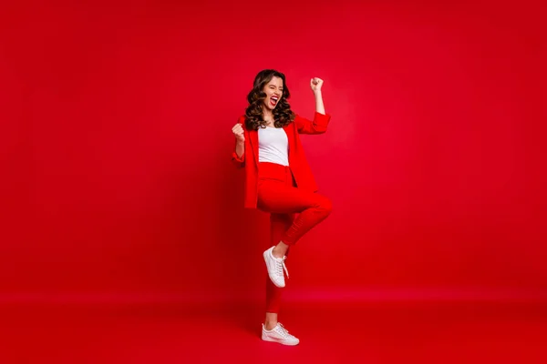 Full size photo of delighted lady raising her fists screaming yeah celebrating victory isolated over red background — Stock Photo, Image