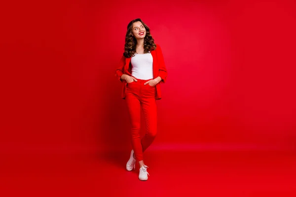 Hela kroppen foto av attraktiv dam tittar upp tänkande bär modern kostym isolerad över röd bakgrund — Stockfoto