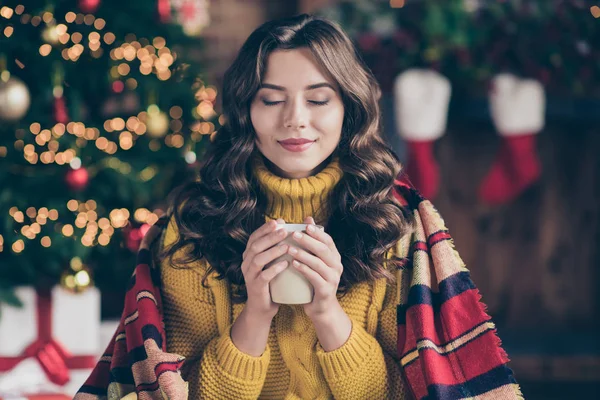 Close up photo of cheerful fun nice positive cute charming girl sensing nice smell of drink wearing yellow pullover sitting in plaid enjoying her carefree leisure with cup of tea — Stock Photo, Image