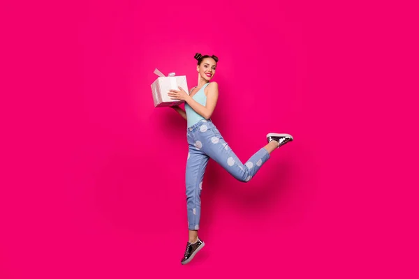 Foto de longitud completa de la señora linda sosteniendo grandes manos giftbox saltando ropa casual de alto desgaste aislado fondo rosa —  Fotos de Stock